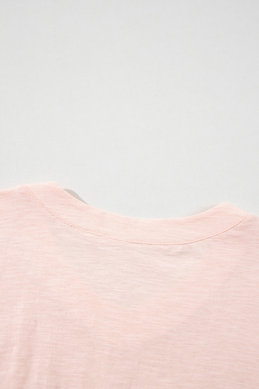 Blusa de corte alto y bajo con costuras expuestas y parches de flores en color rosa albaricoque y talla grande