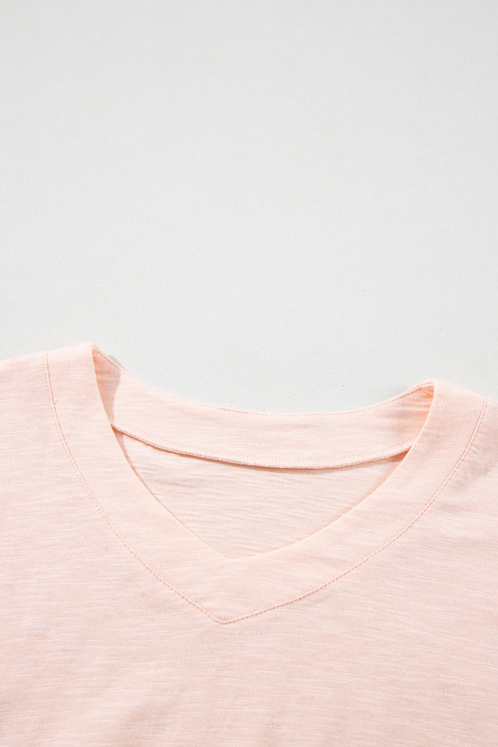 Blusa de corte alto y bajo con costuras expuestas y parches de flores en color rosa albaricoque y talla grande