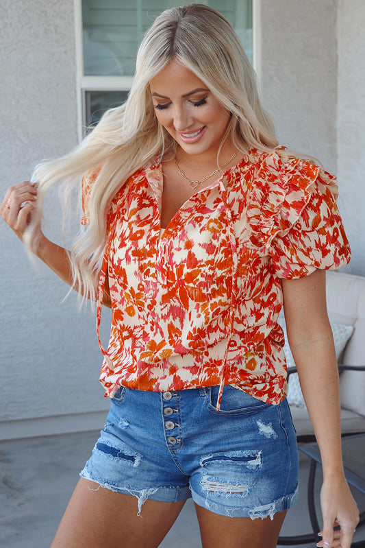 Blusa con cuello abierto, mangas abullonadas cortas y volantes con estampado floral naranja