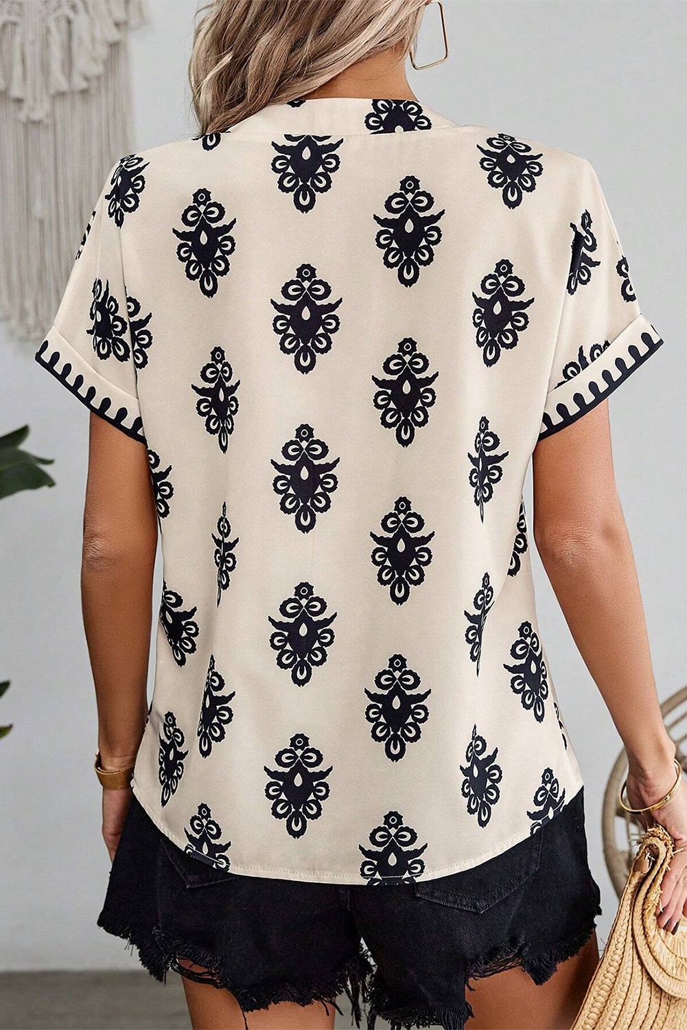 Blusa negra con cuello en V y manga corta con estampado geométrico