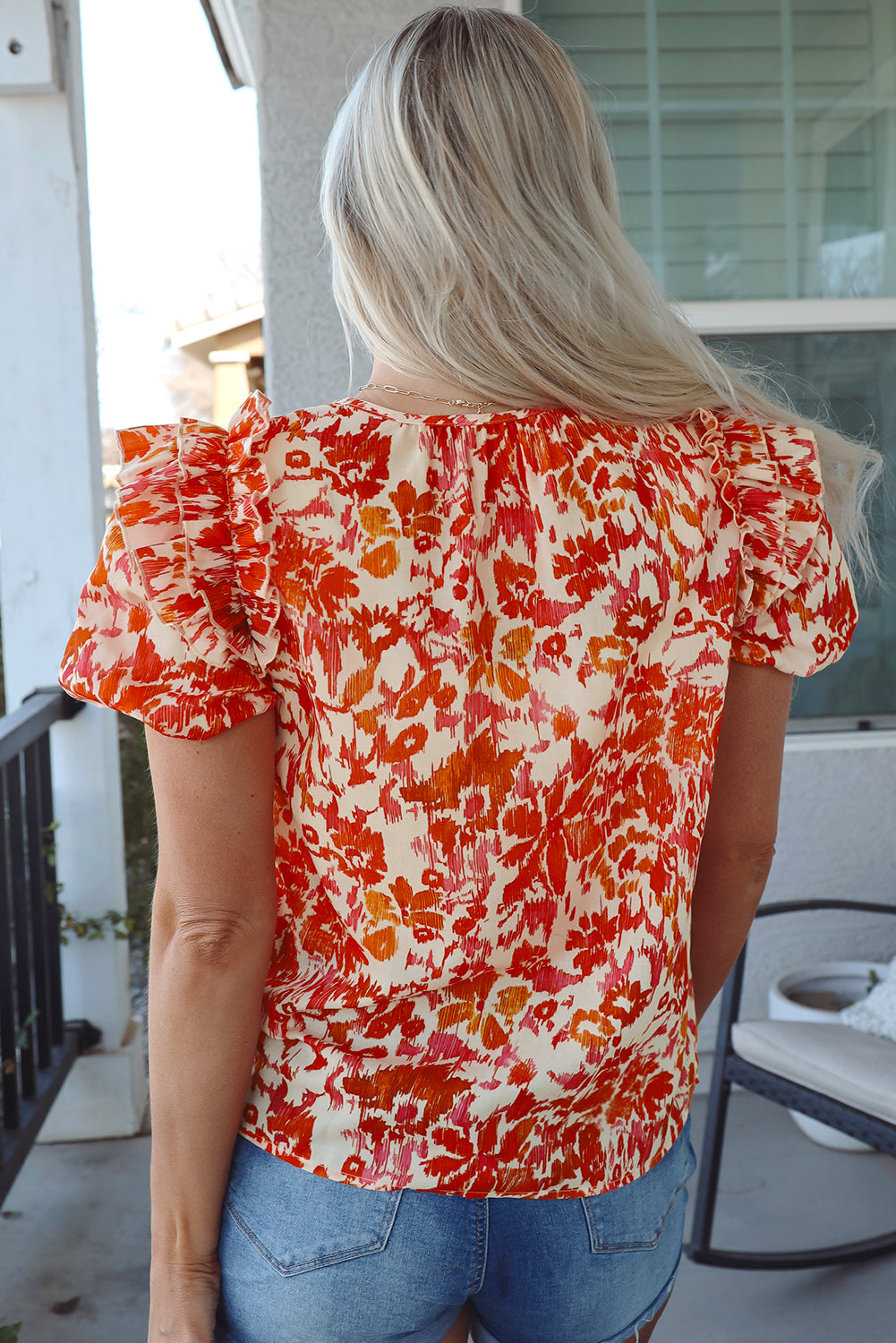 Blusa con cuello abierto, mangas abullonadas cortas y volantes con estampado floral naranja