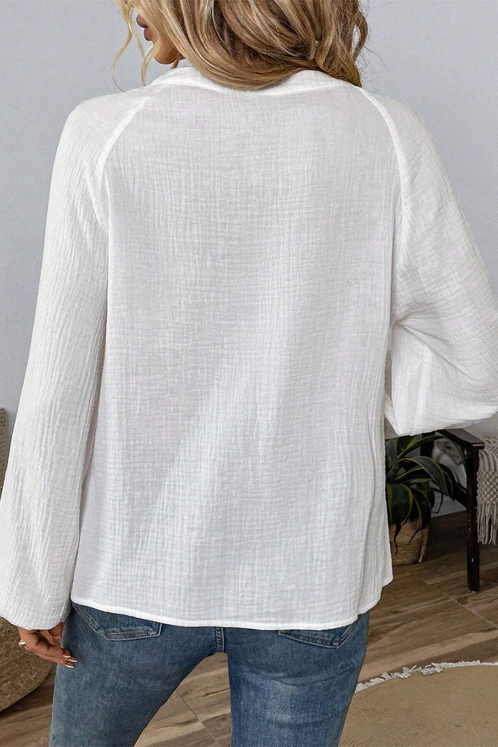 Blusa blanca con mangas largas abullonadas, cuello abierto y textura bordada con cachemira