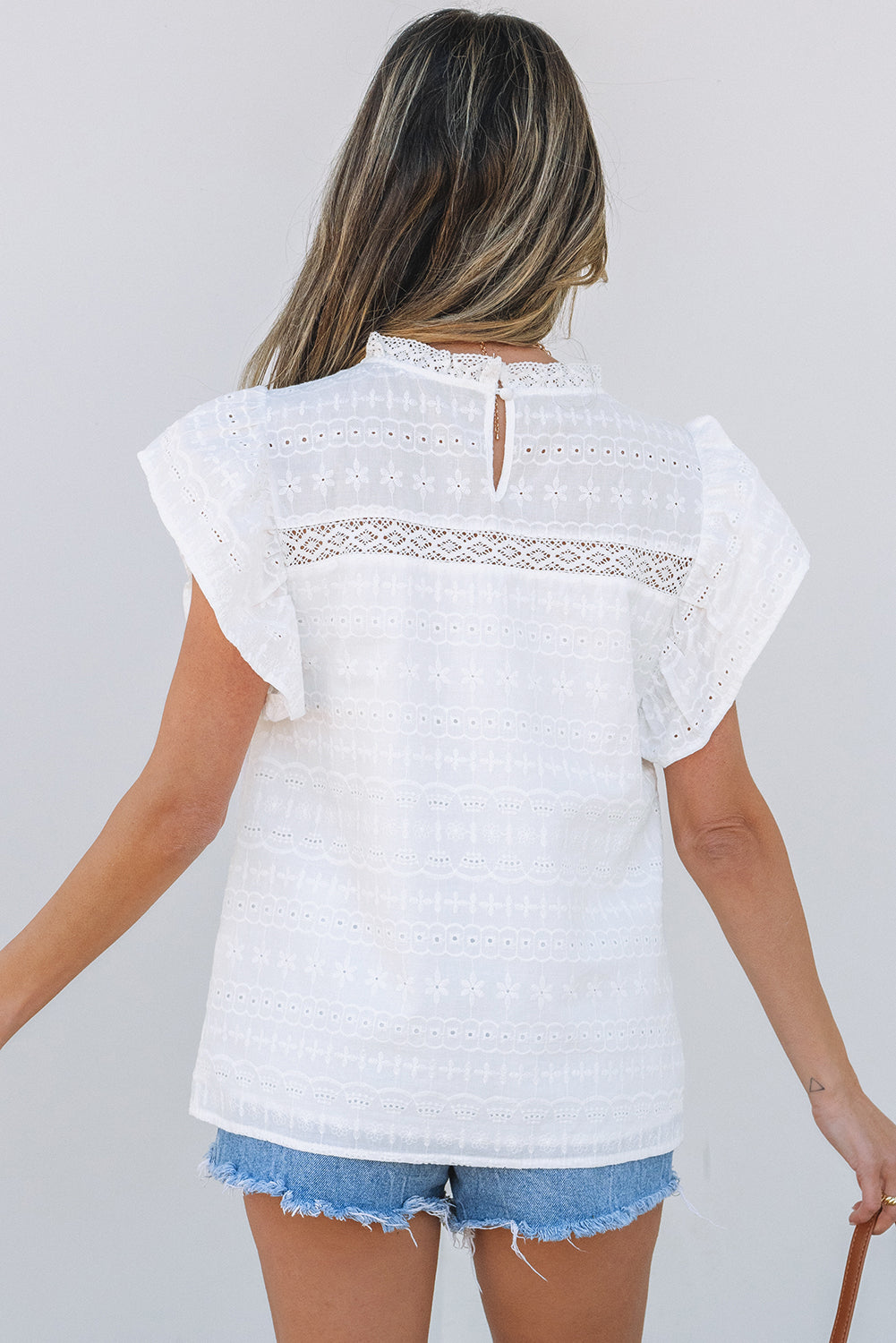 Blusa con ojales y mangas con vuelo y escote de encaje blanco